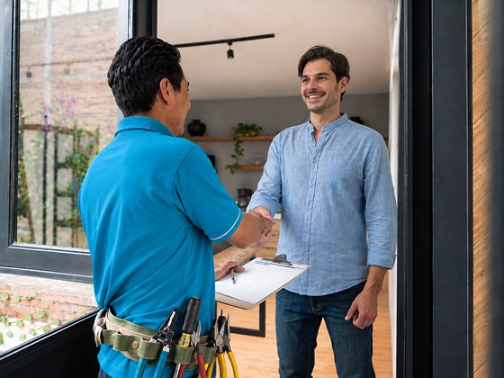 Quick Replace tradesperson shaking hands with a customer at the front door