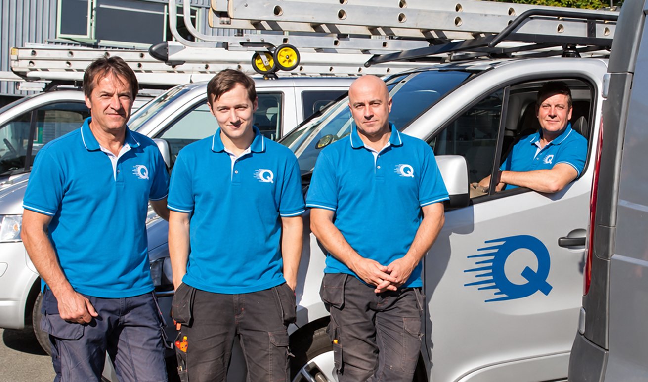 The Quick Replace team in uniform beside their work vans