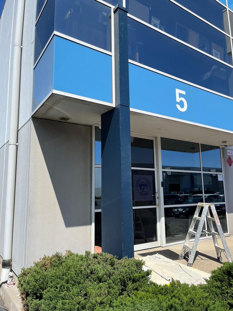 Commercial building entrance with a freshly painted navy column