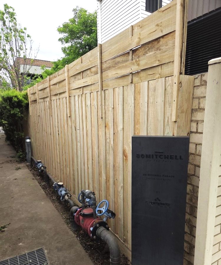 New timber paling boundary fence along a building walkway
