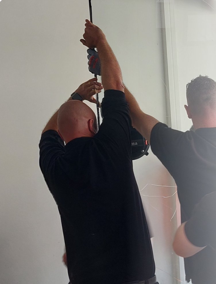 Technicians fitting a large glass panel