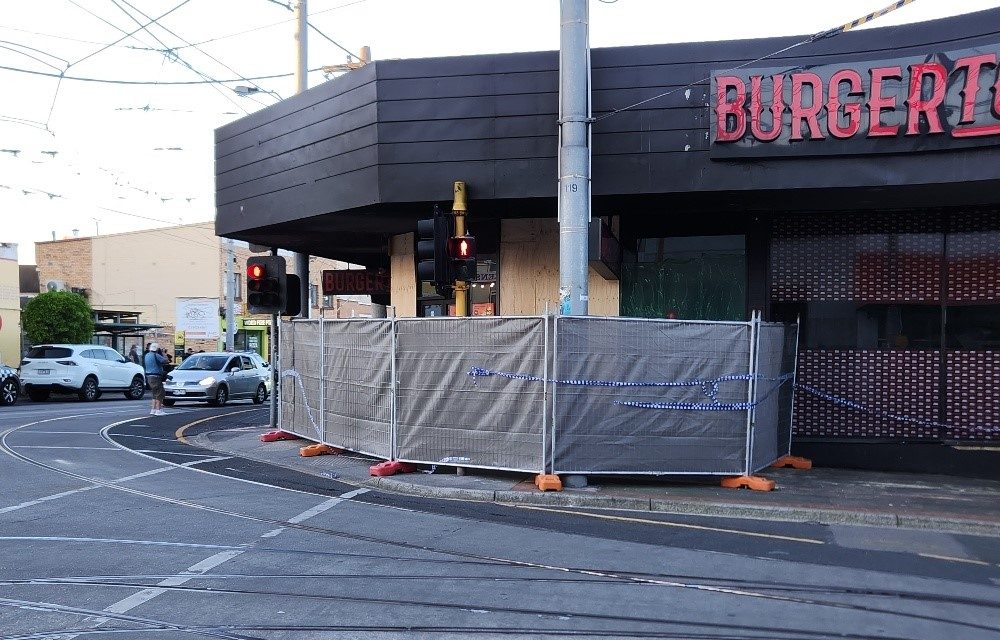 Temporary fencing set up around a damaged corner shopfront