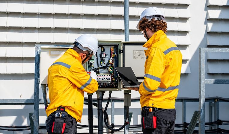 Electrician testing a switchboard with a multimeter