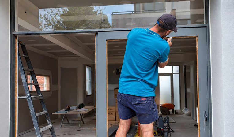 Glazier cutting a sheet of glass to size