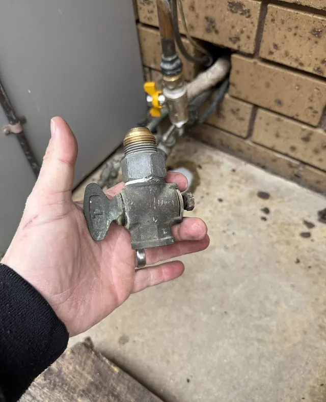 Old corroded plumbing valve removed from beside a hot water unit